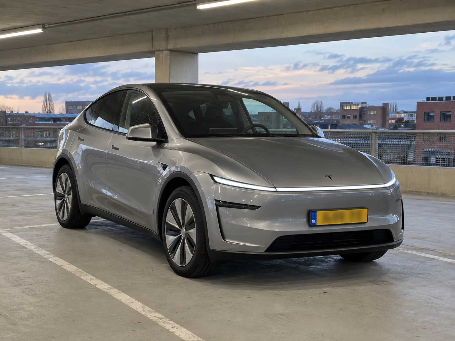 Zilveren Tesla Model Y met Nederlands kenteken in een Nederlandse parkeergarage.